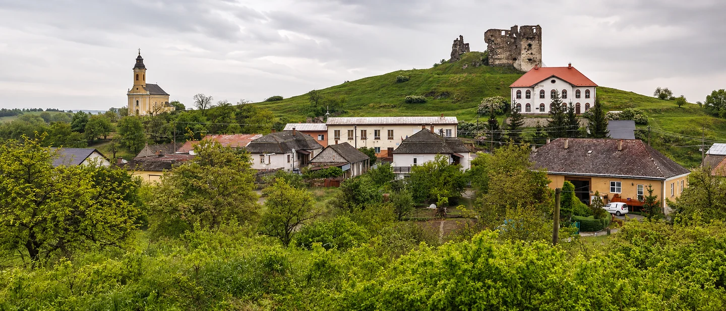 Királyhelmec panorámája a templommal és a zöld dombon álló várral